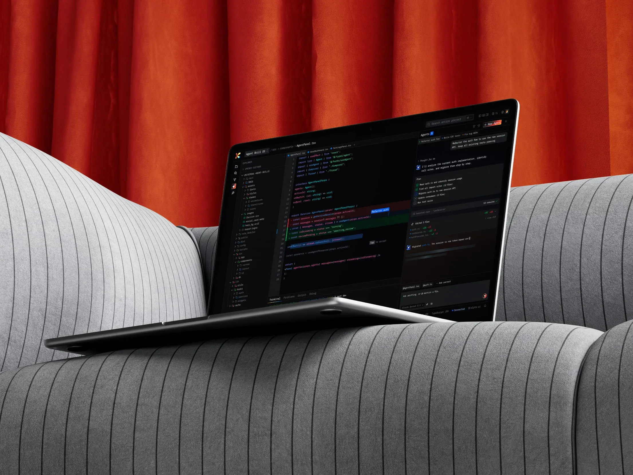AI coding agent interface on a laptop in front of an orange curtain