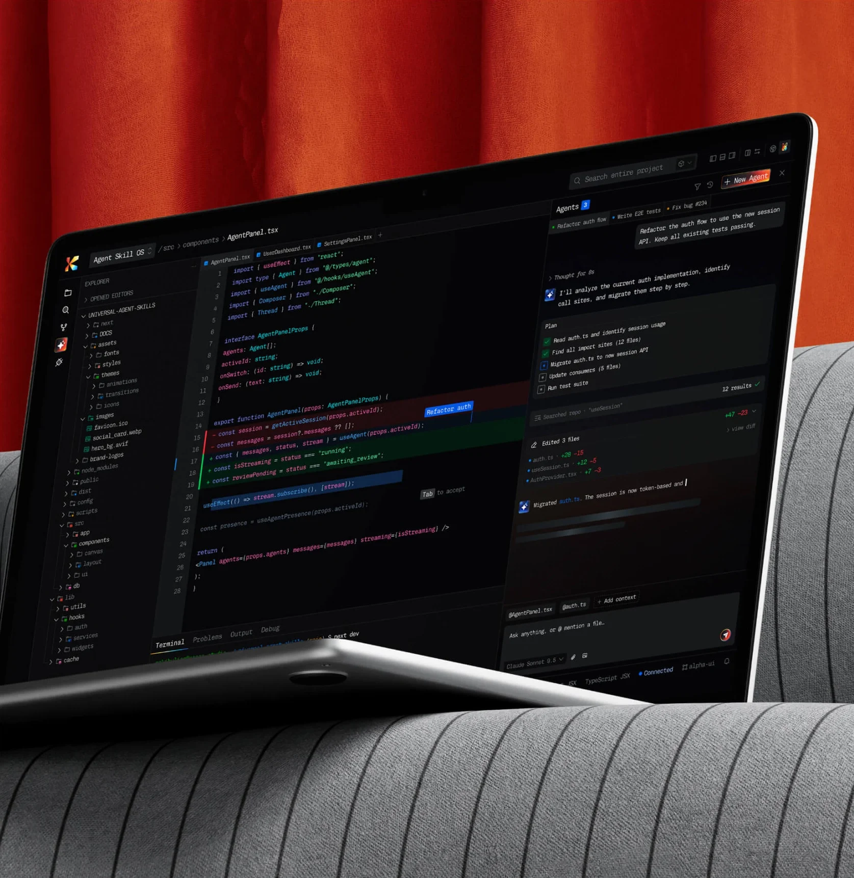AI coding agent interface on a laptop in front of an orange curtain